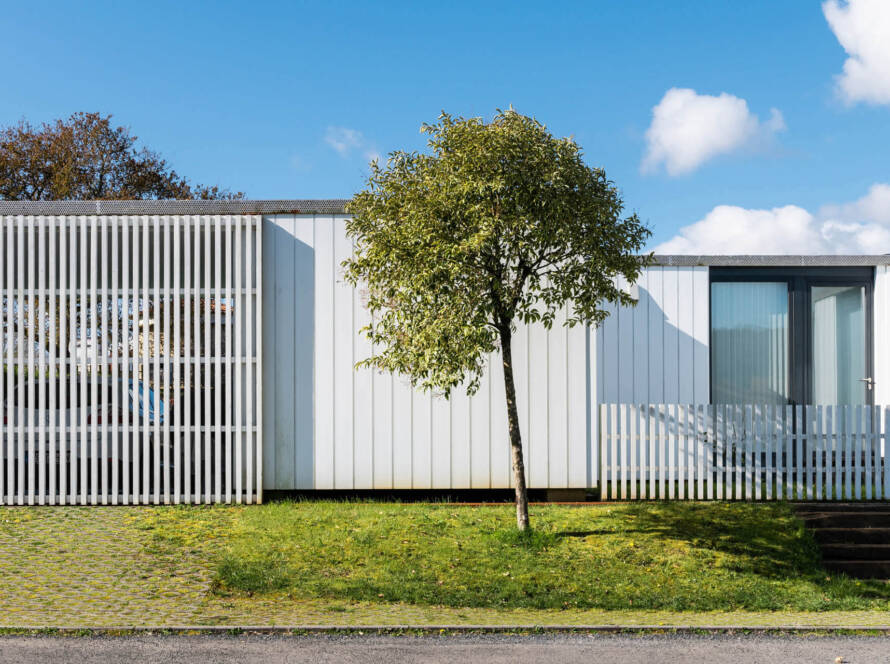 Bungalow mit Zaun und Baum