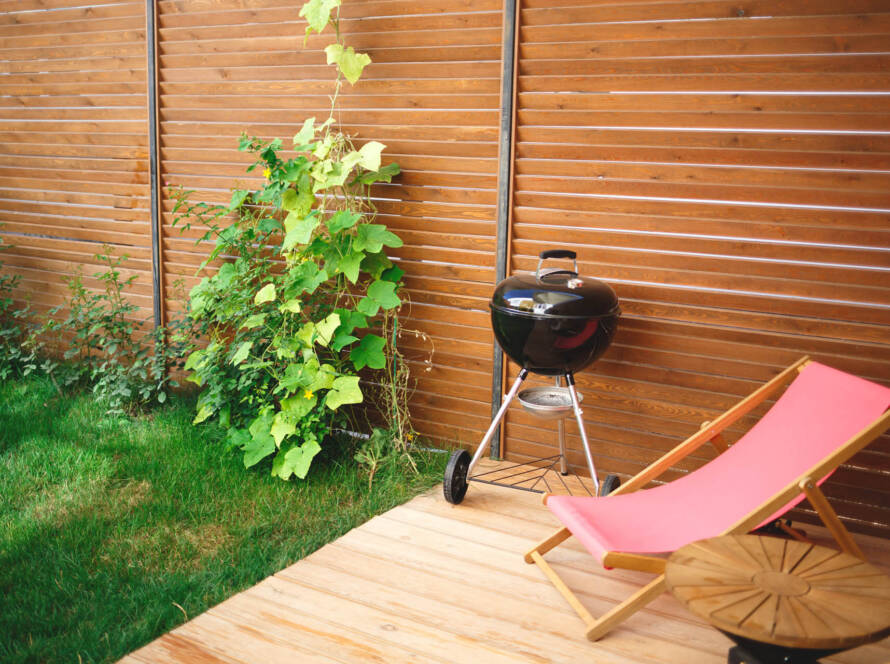 Terrasse mit günstigem Holzzaun als Grenzbebauung und Einfriedung zum Nachbarn